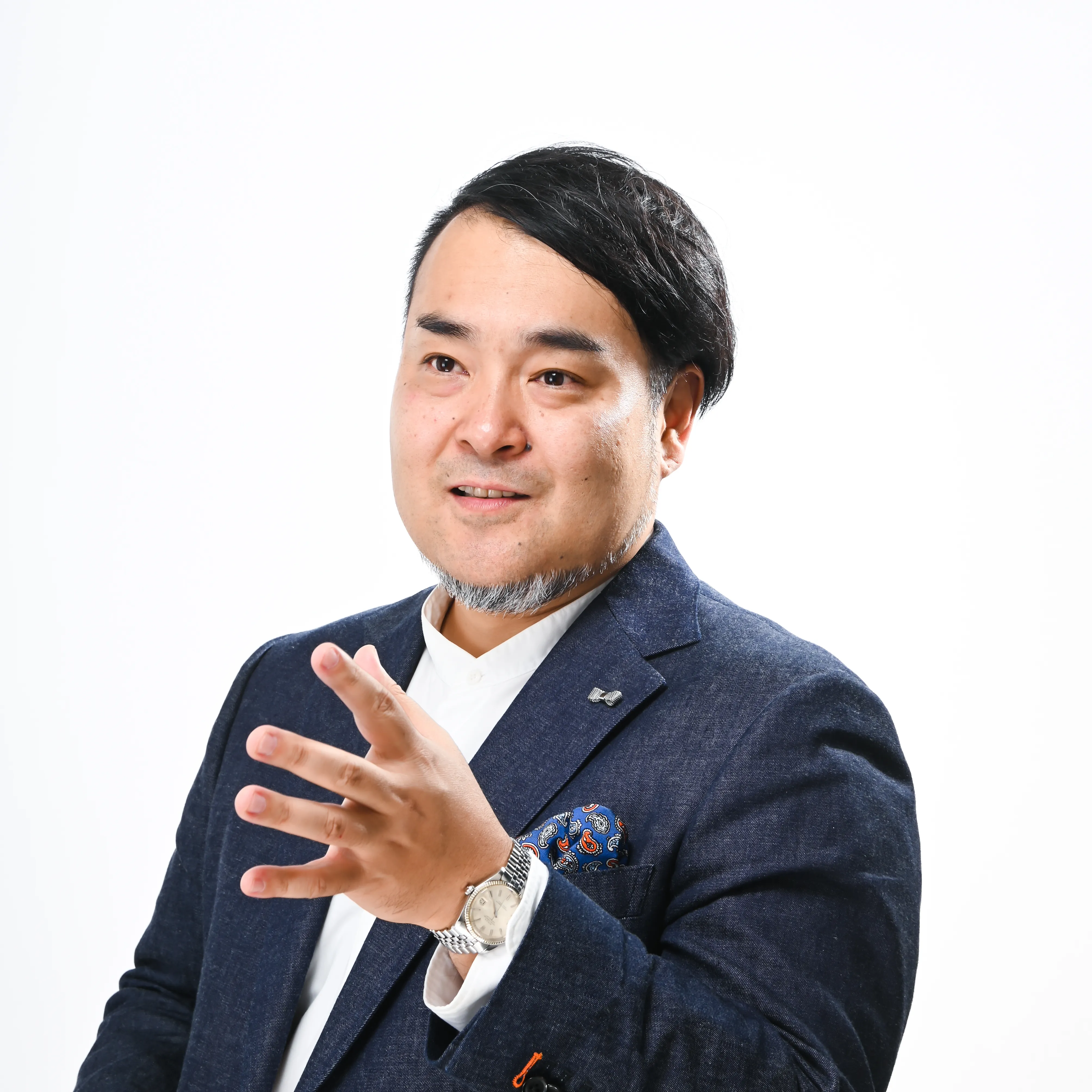 手を動かしながら話す鈴木ケンジのポートレート