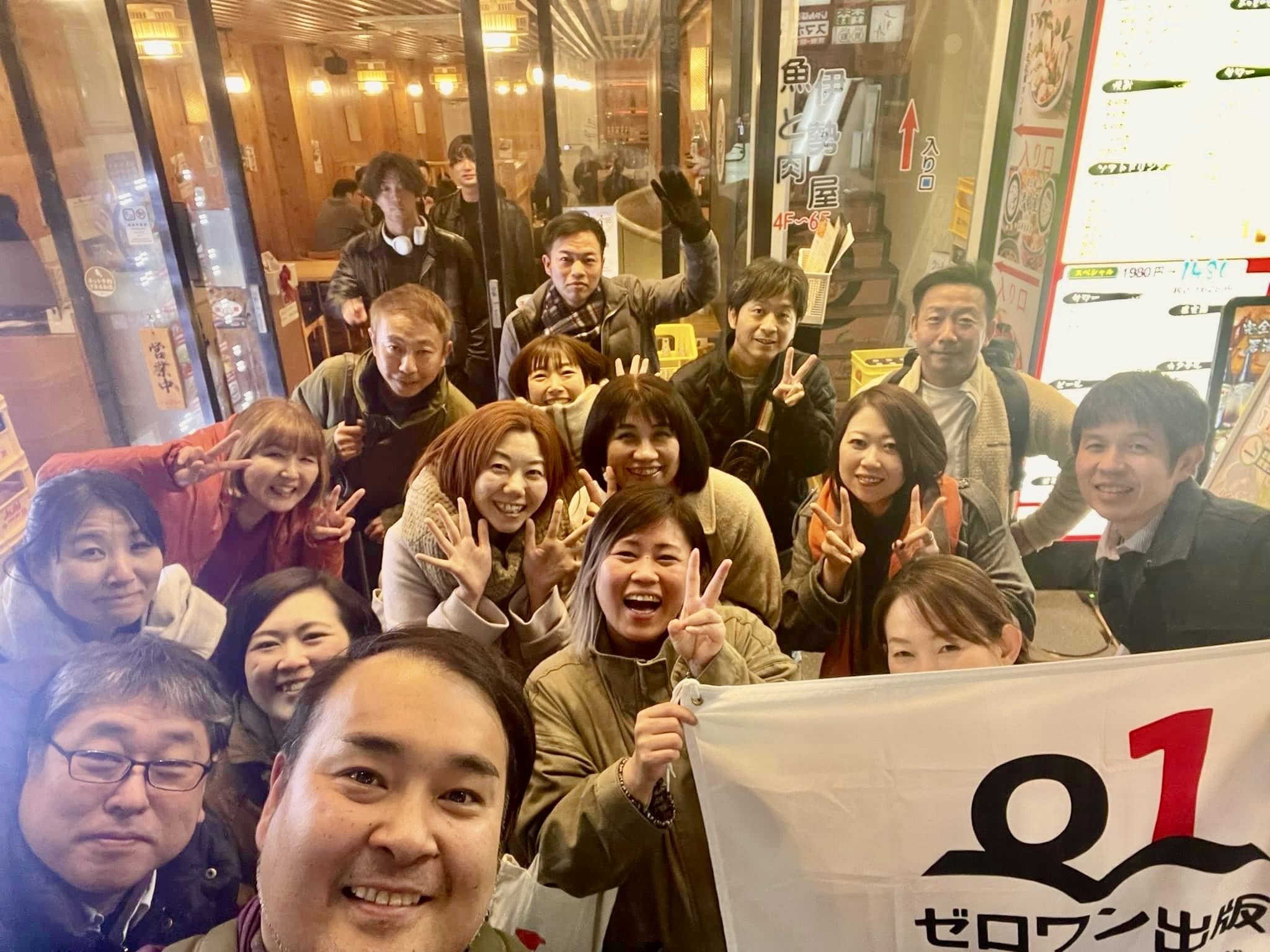 ゼロワン出版の旗とともに撮影した集合写真